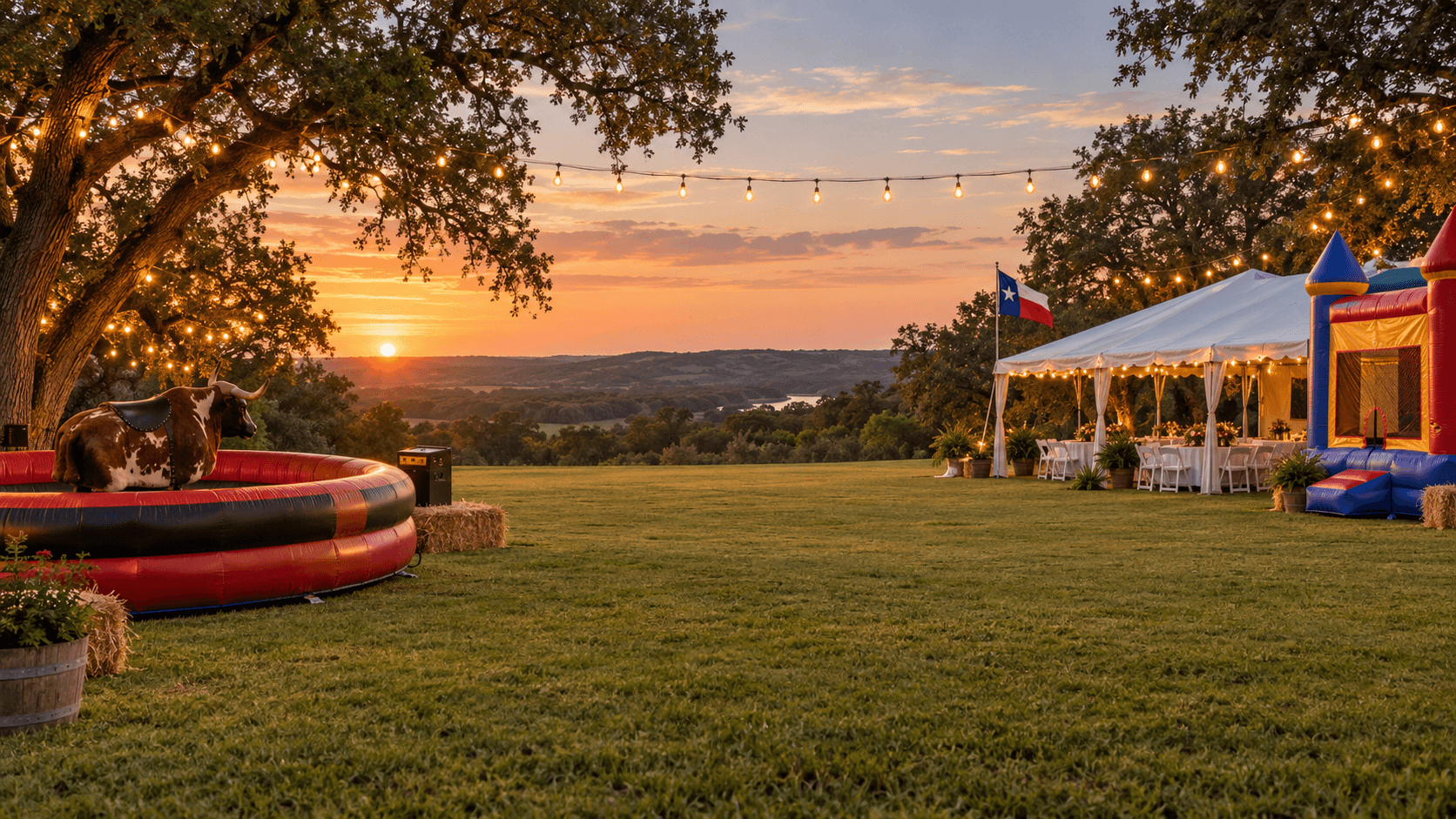 Texas hill country party setup at sunset with a mechanical bull, bounce house, string lights and a reception tent